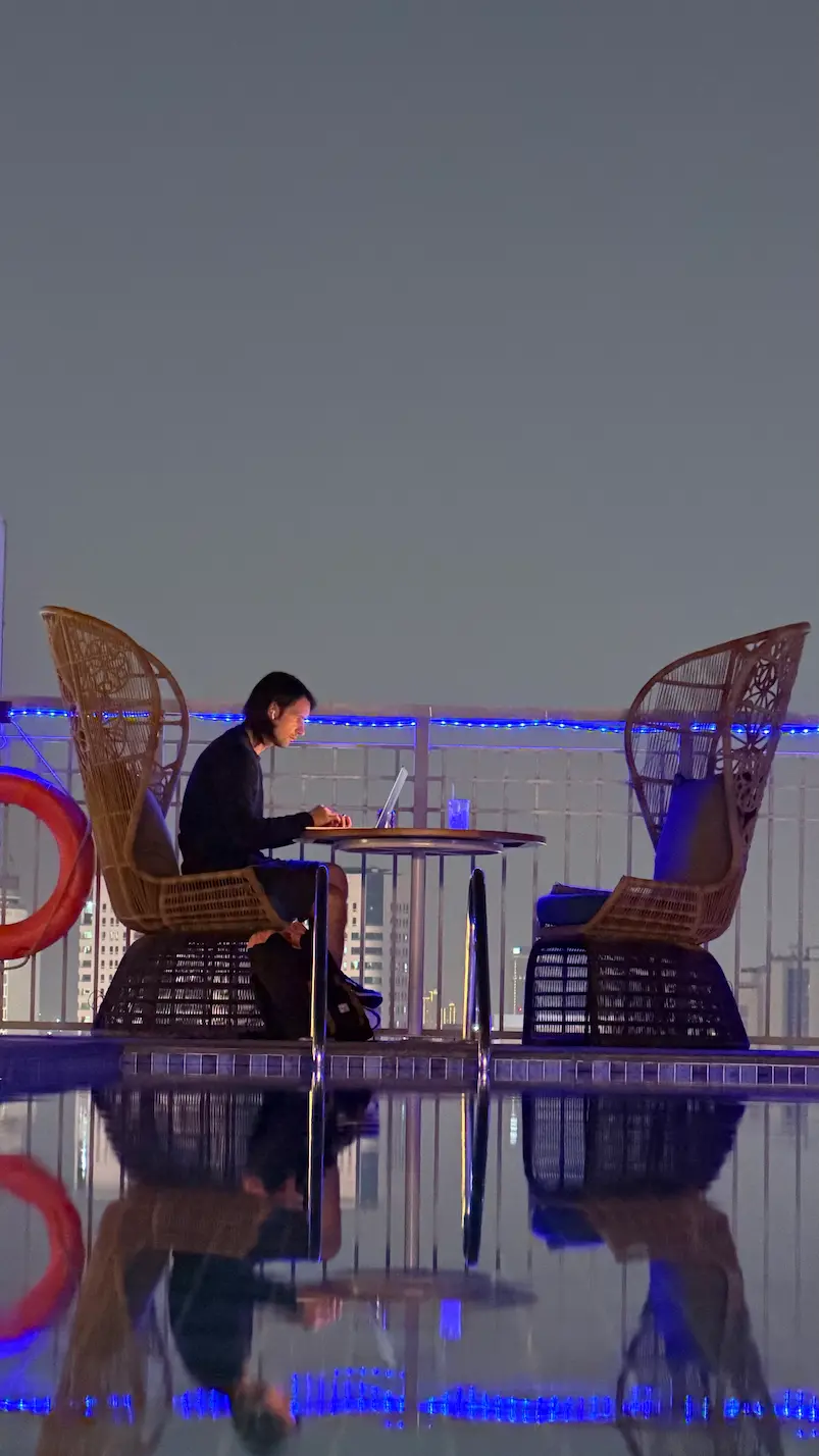Gabriele lavora al laptop di notte su un rooftop a Dubai